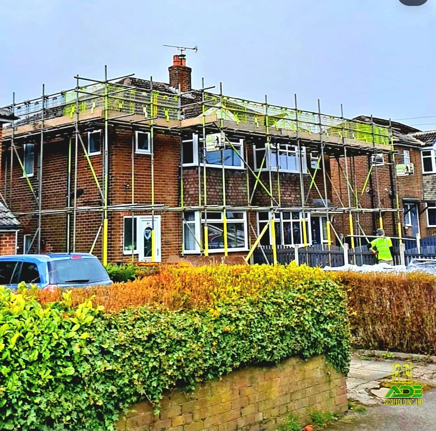 Two-lift front scaffold spanning a terraced row with green debris mesh