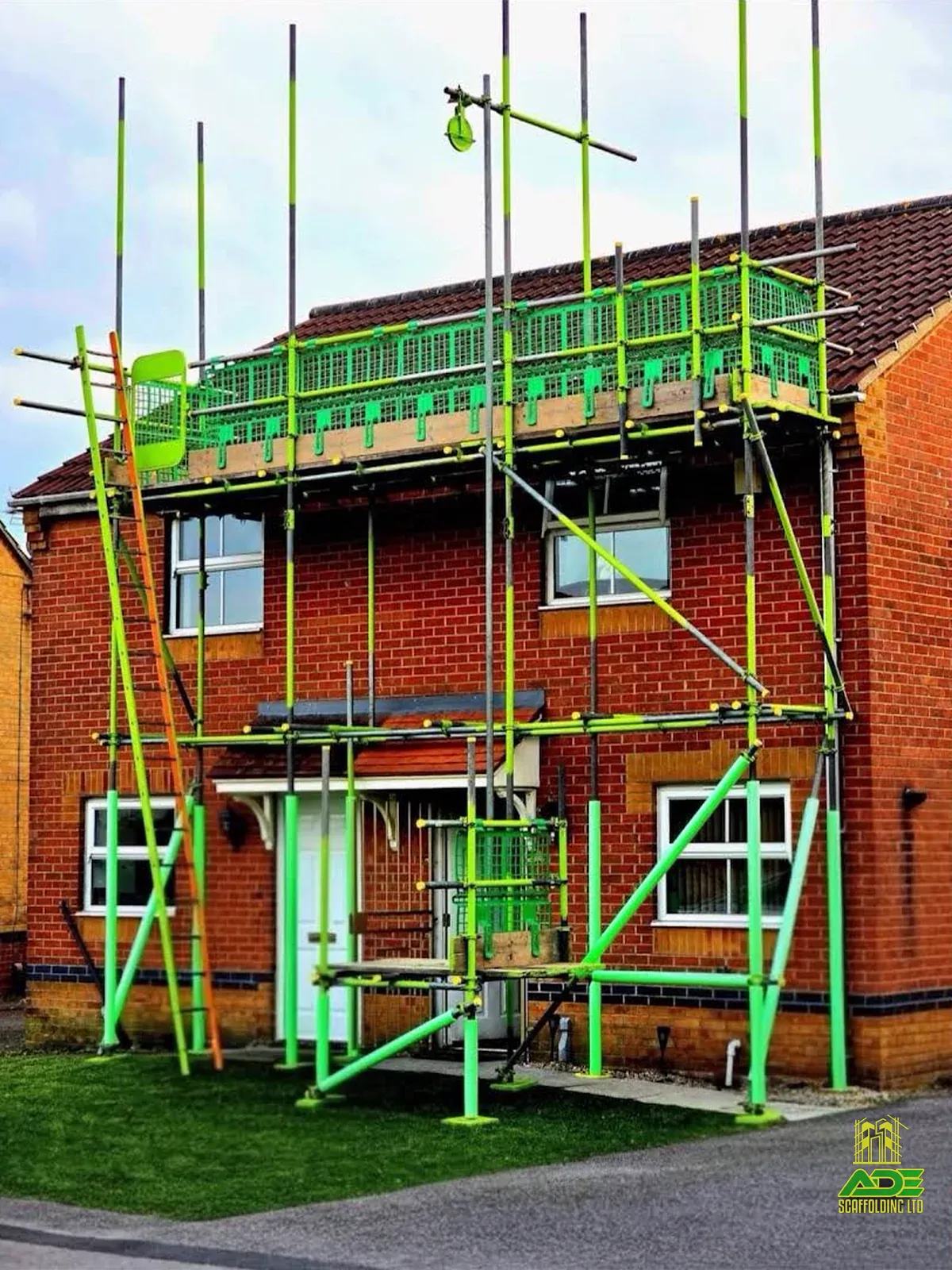 Lime-green front scaffold on a red-brick semi with white door